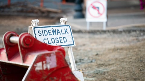 Road construction signs. Sidewalk closed. One way street with detour.