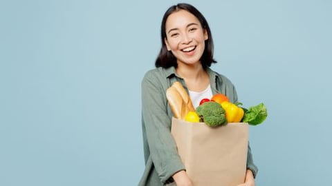 Happy female shopper with grocery bag