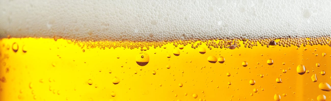 Beer background with bubble froth texture foam pouring alcohol soda in glass 