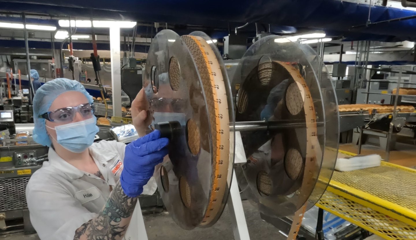 Bimbo Canada associate in Moncton, New Brunswick tightens a reel of compostable bread bag clips that once transitioned, will eliminate the company’s single-use plastics 