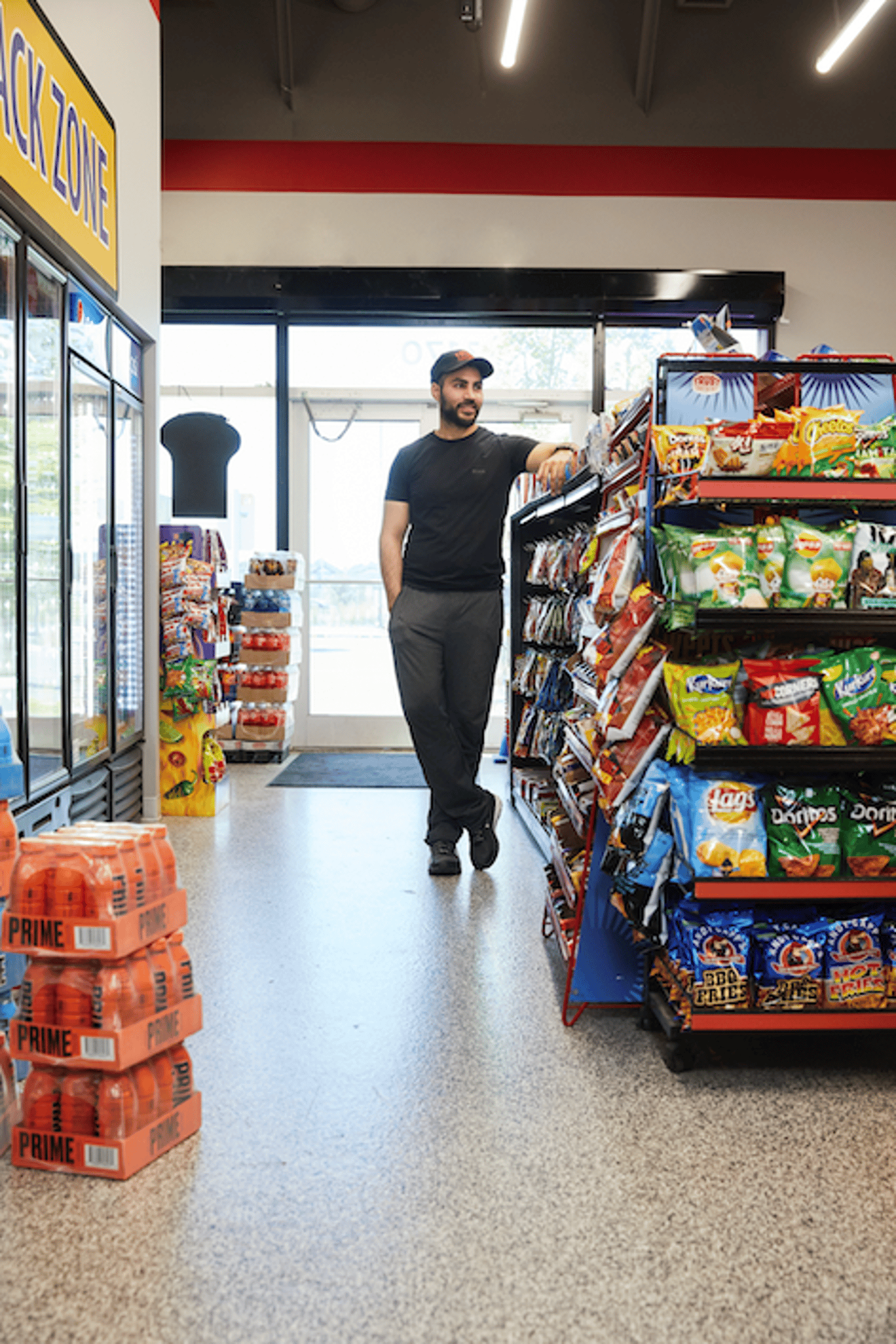 Dharmender Khosa standing in aisle of Trust Convenience