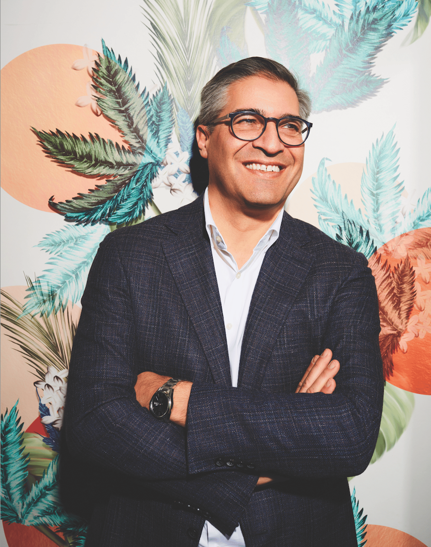 Stephane Trudel with his arms crossed in front of a colourful wall in the Fire and Flower store