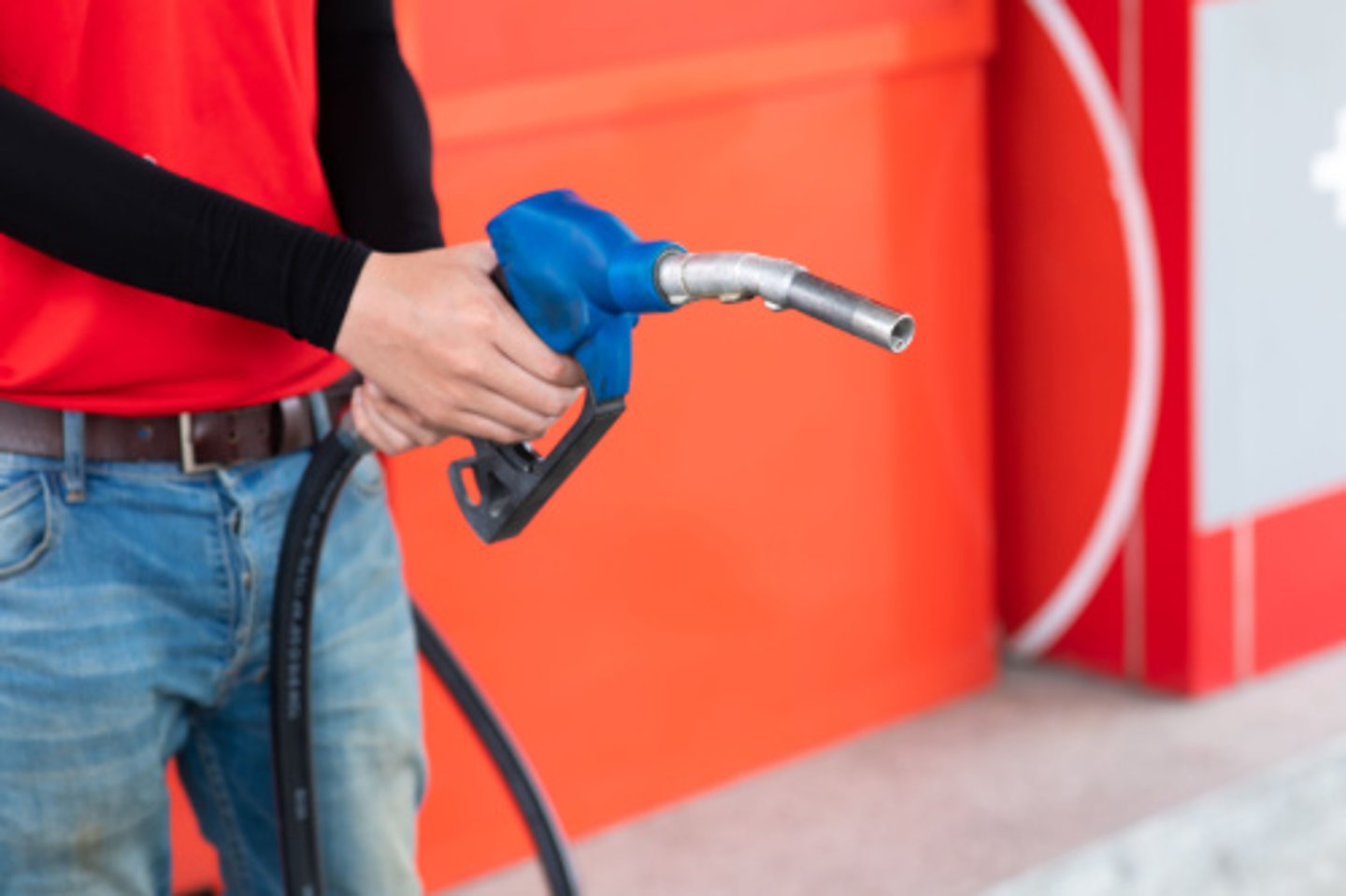 Man  hand holding nozzle to refuel the car