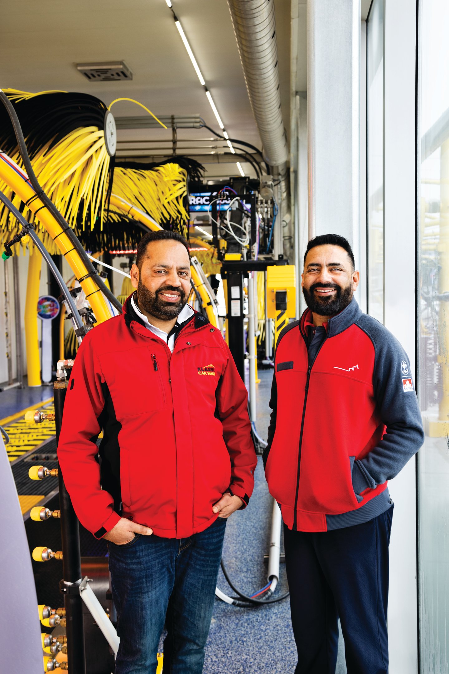 Tony Thind and Rozy in front of Klassic Car Wash's automatic carwash system.