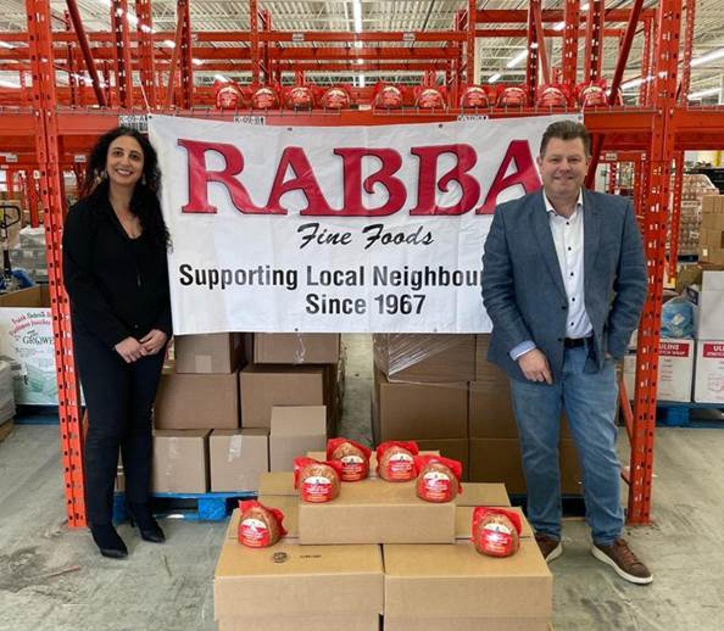 Rima Rabba, leader of the Rabba Roots Community Giving Program and Stephen Carroll, Customer Business Development Manager at Maple Leaf Foods deliver hams to The Mississauga Food Bank just in time for Easter weekend.