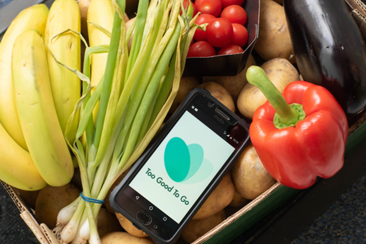 Tilburg, Netherlands - 05.18.221: Box of almost expired food - vegetables and fruits saved from waste with Too Good To Go app. Zero waste grocery shopping via app fighting with throwing out food.