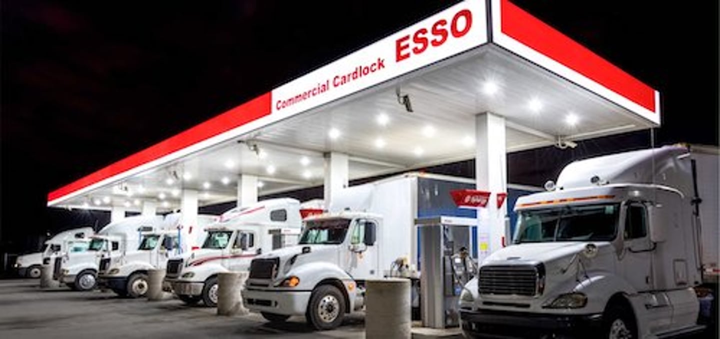 Multiple trucks in front of an Esso station