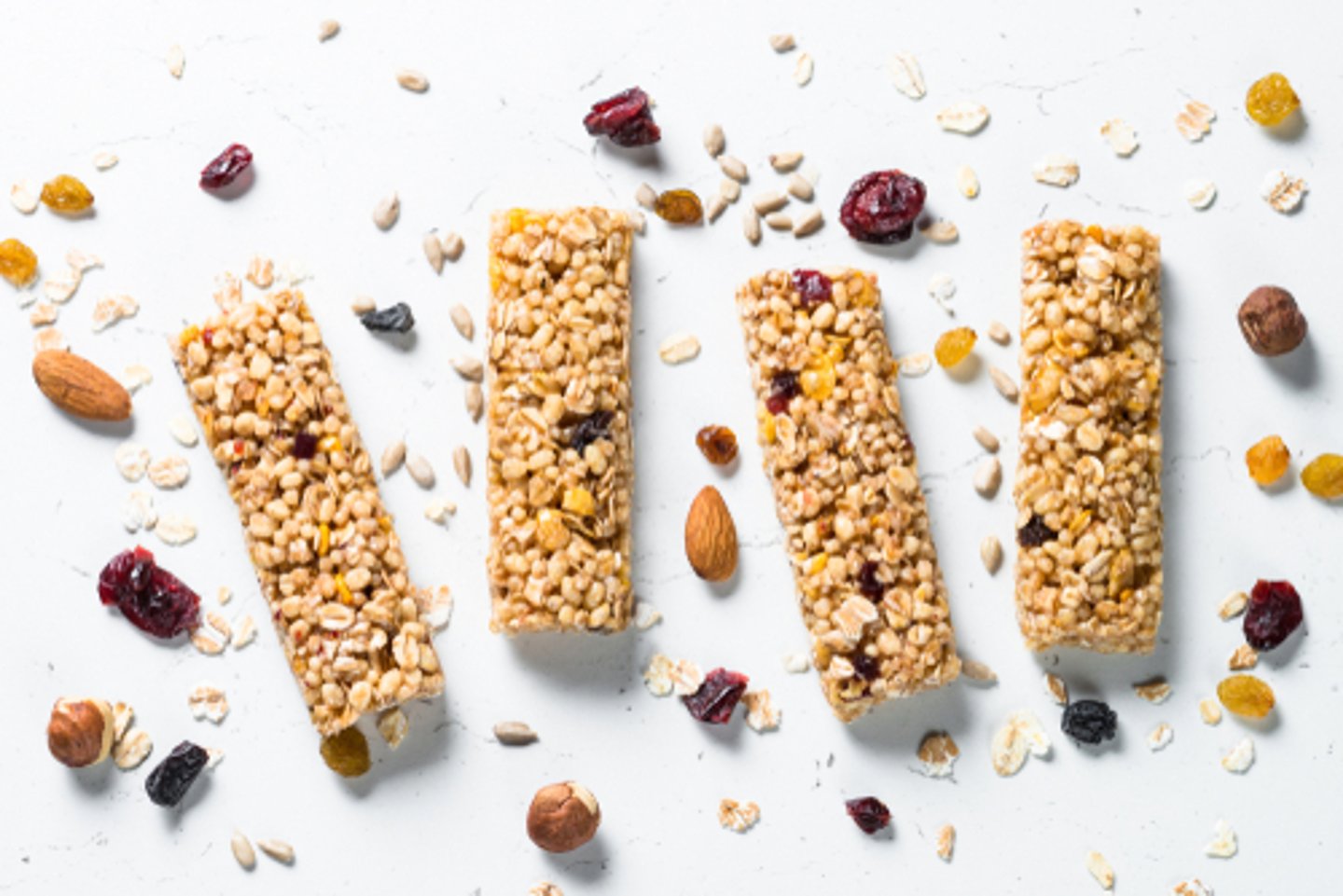 Granola bar. Healthy sweet dessert snack. Cereal granola bar with nuts, fruit and berries on a white stone table. Top view.