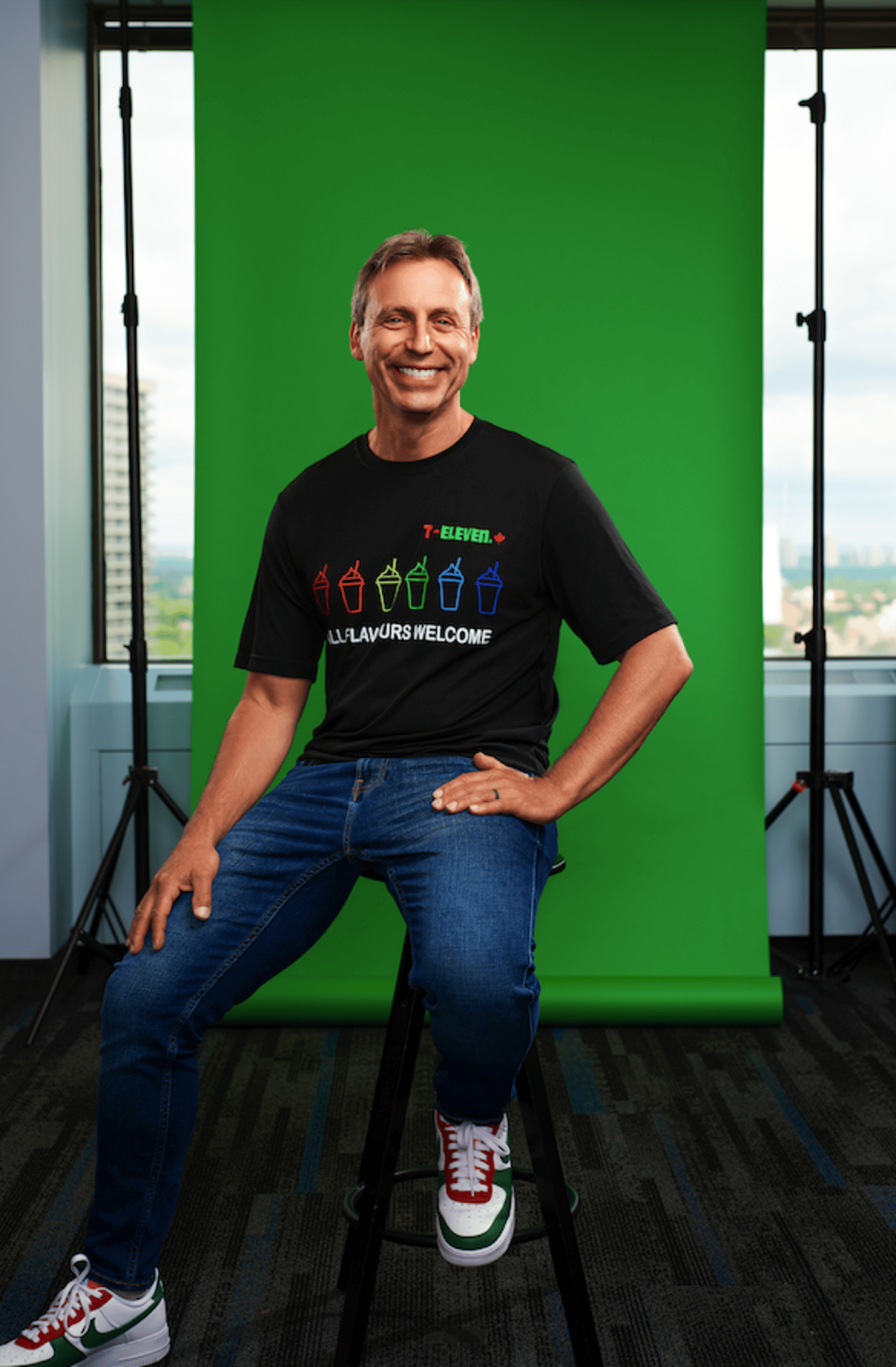 Marc Goodman sitting on a stool in front of a green background