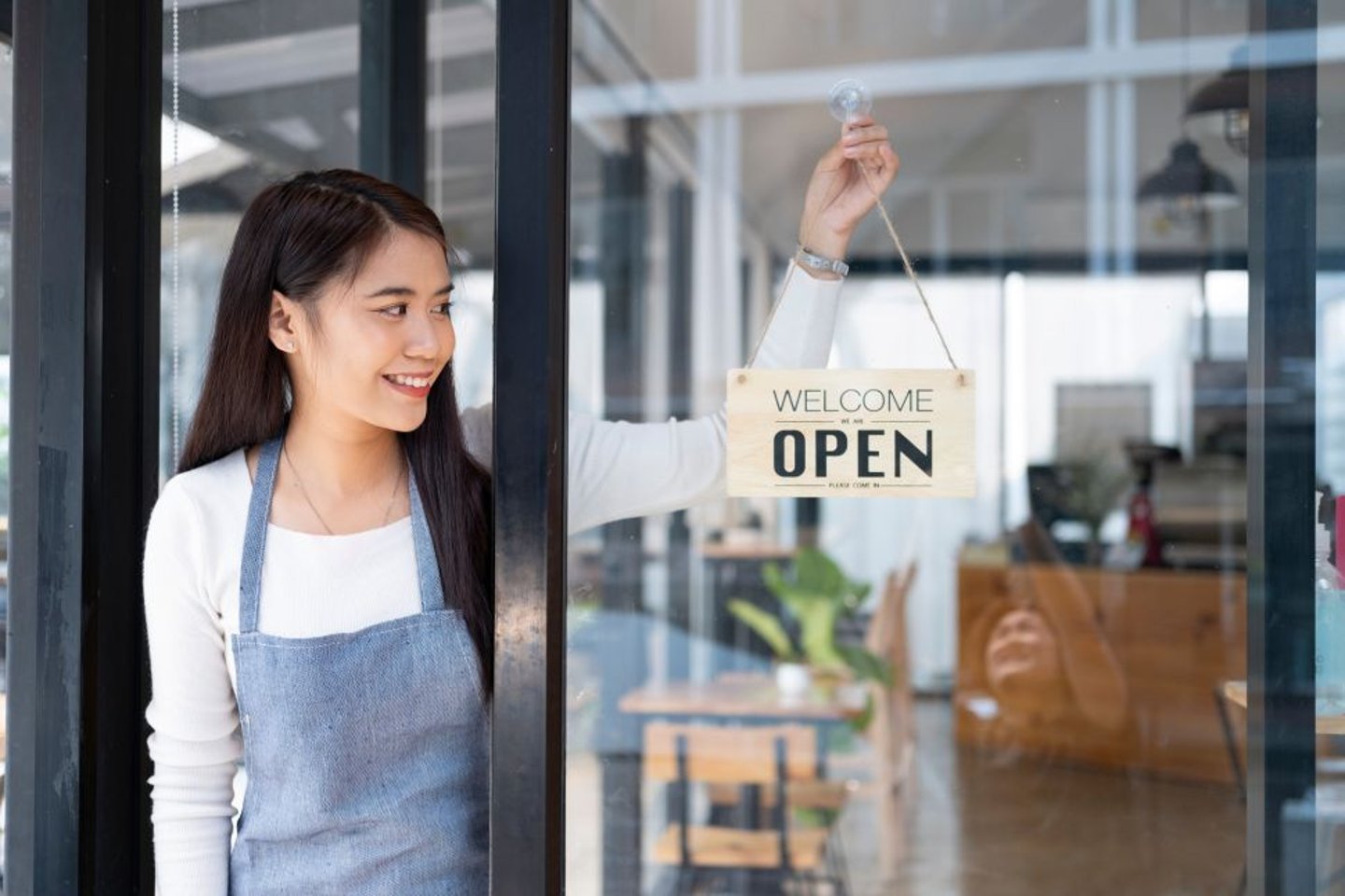 Woman putting up an open sign