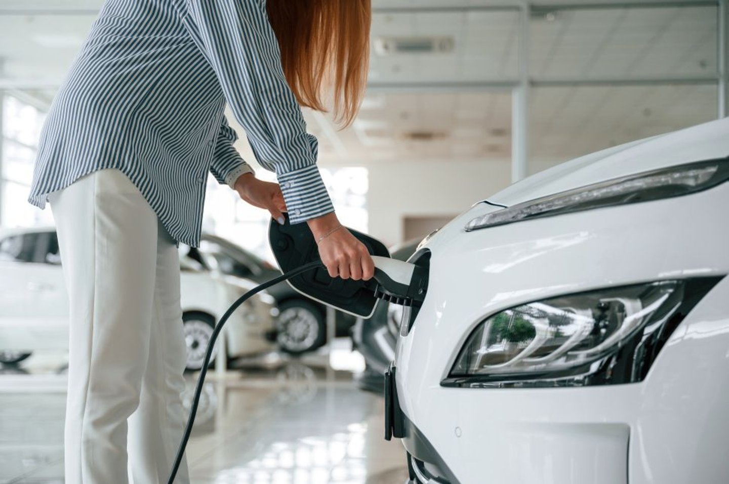 Woman Charging EV stock image