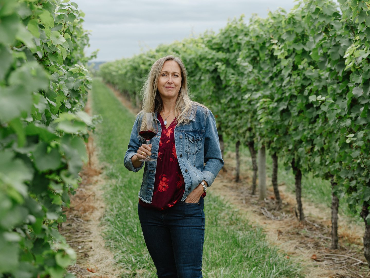 Emma Garner in a vineyard holding a glass of wine