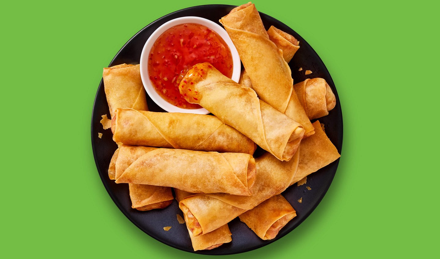 Plate of spring roles with cup of red chile dipping sauce