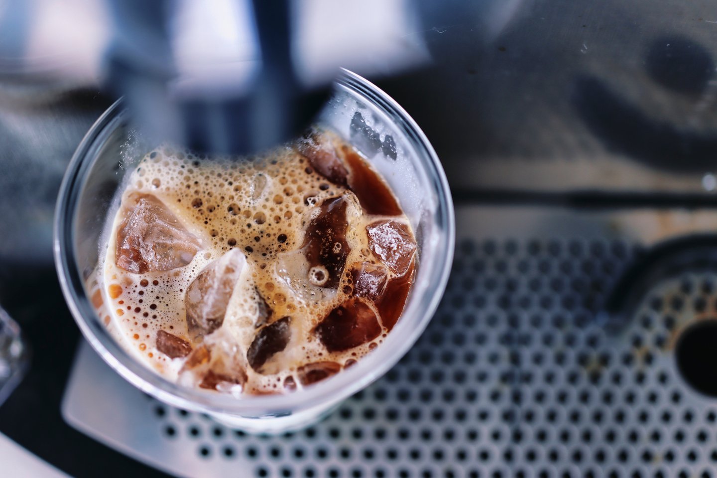 Overview of cold coffee being poured into cup of ice