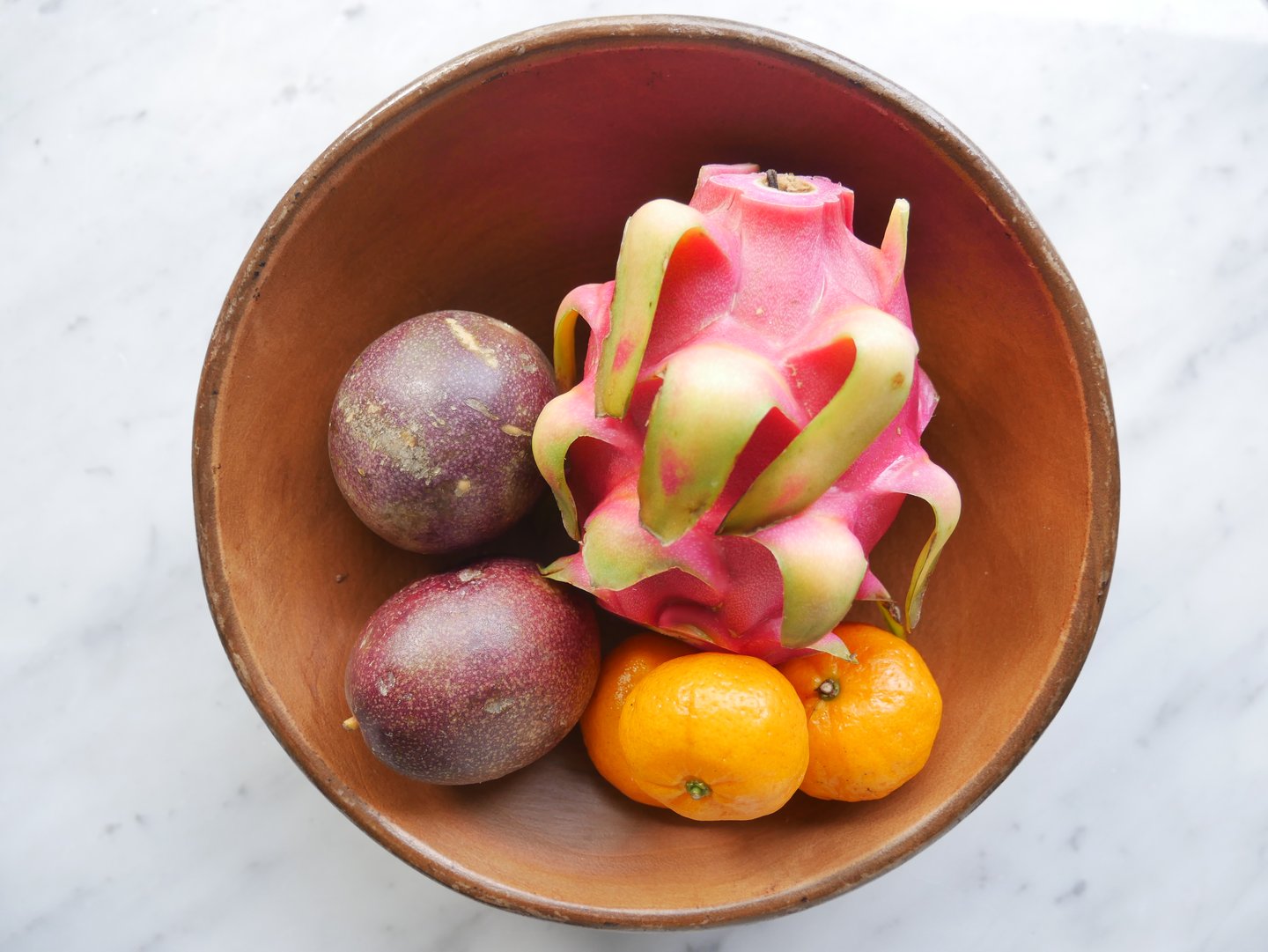 passionfruit, dragon fruit and oranges in a bowl