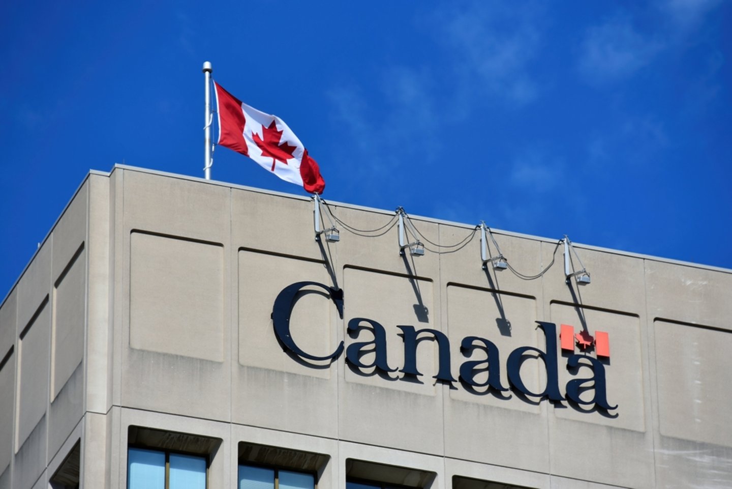 Close up of a Canadian government building, with Canadian flag on the roof.