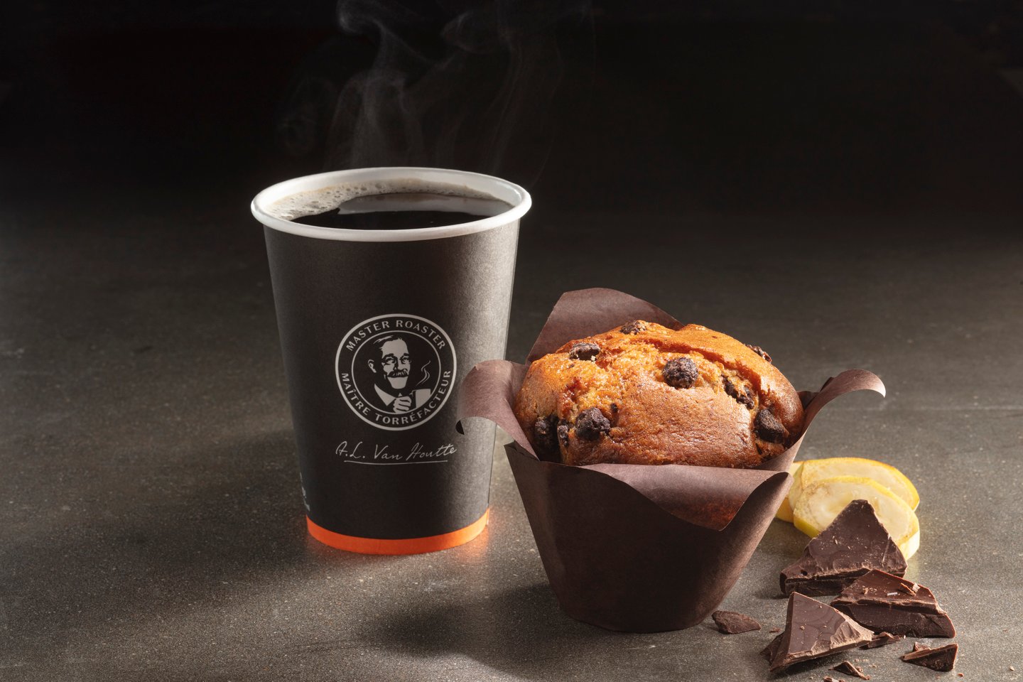 coffee in brown paper cup alongside muffin