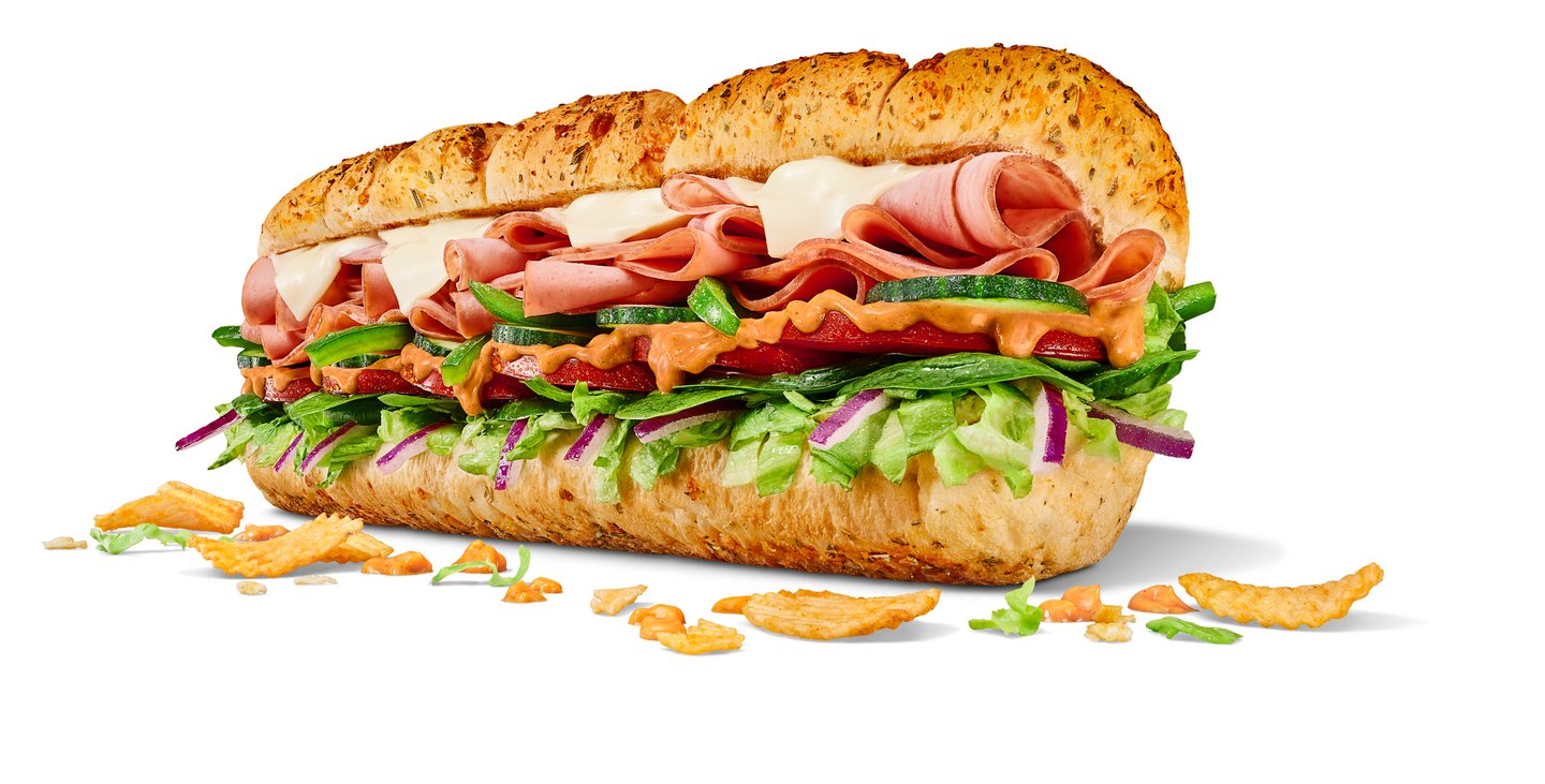 subway sandwich on white background, stacked with ingredients and drizzled with All Dressed Sauce