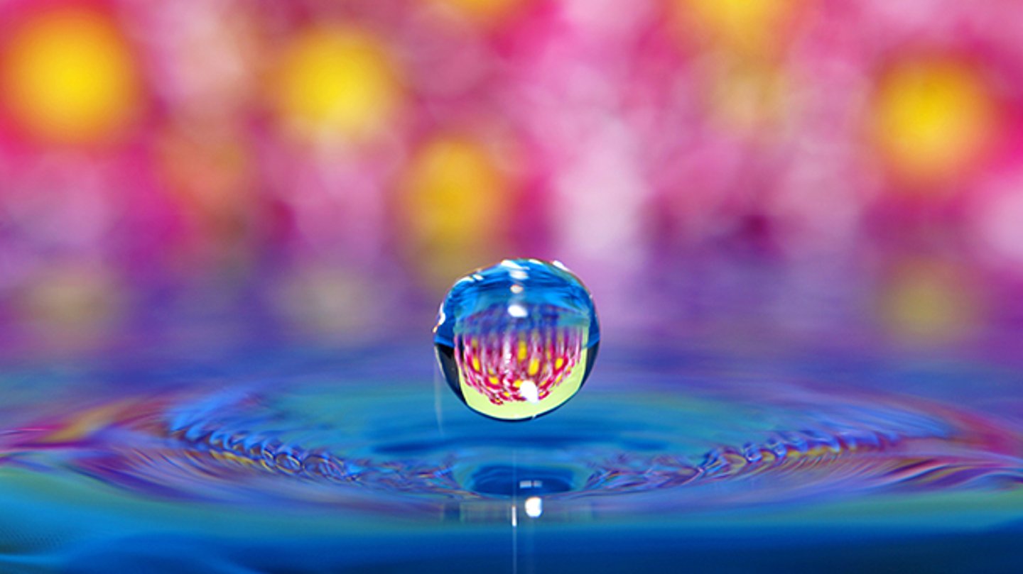 A close up of a multicoloured soap bubble set against bright lights