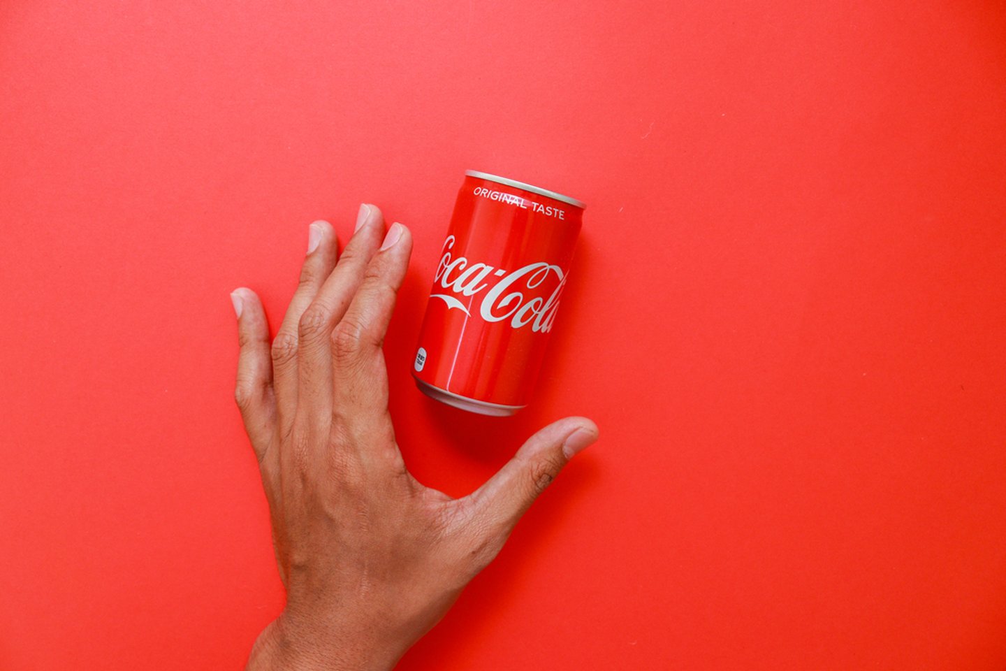 hand reaching for Coca-Cola mini can