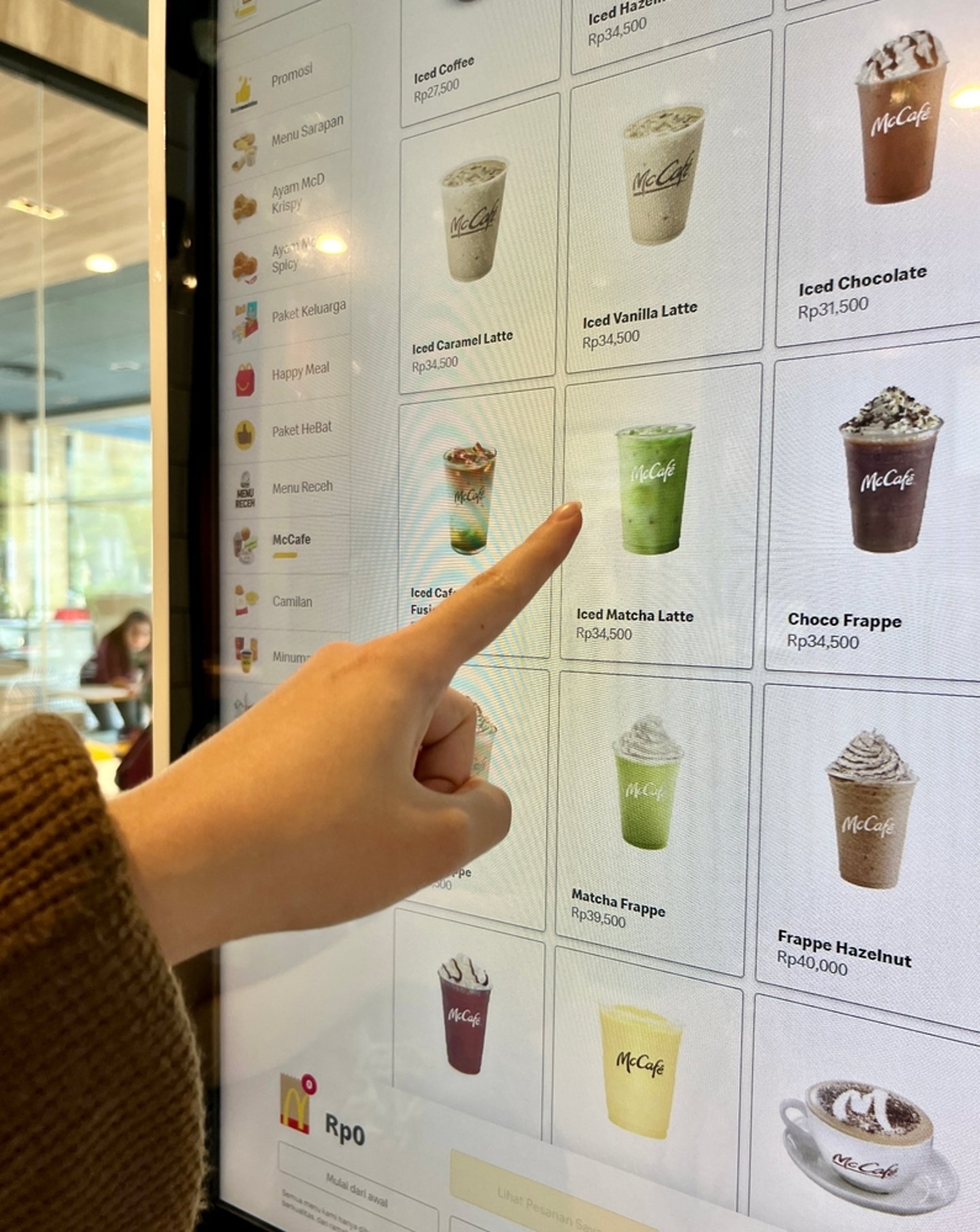hand selecting a drink from McDonald's electronic drinks menu