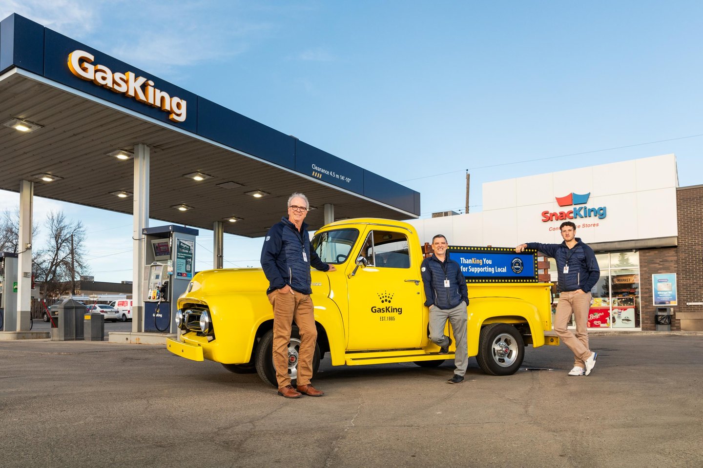 Brent Morris, left, in front of a bright yellow truck in Gas King's forecourt