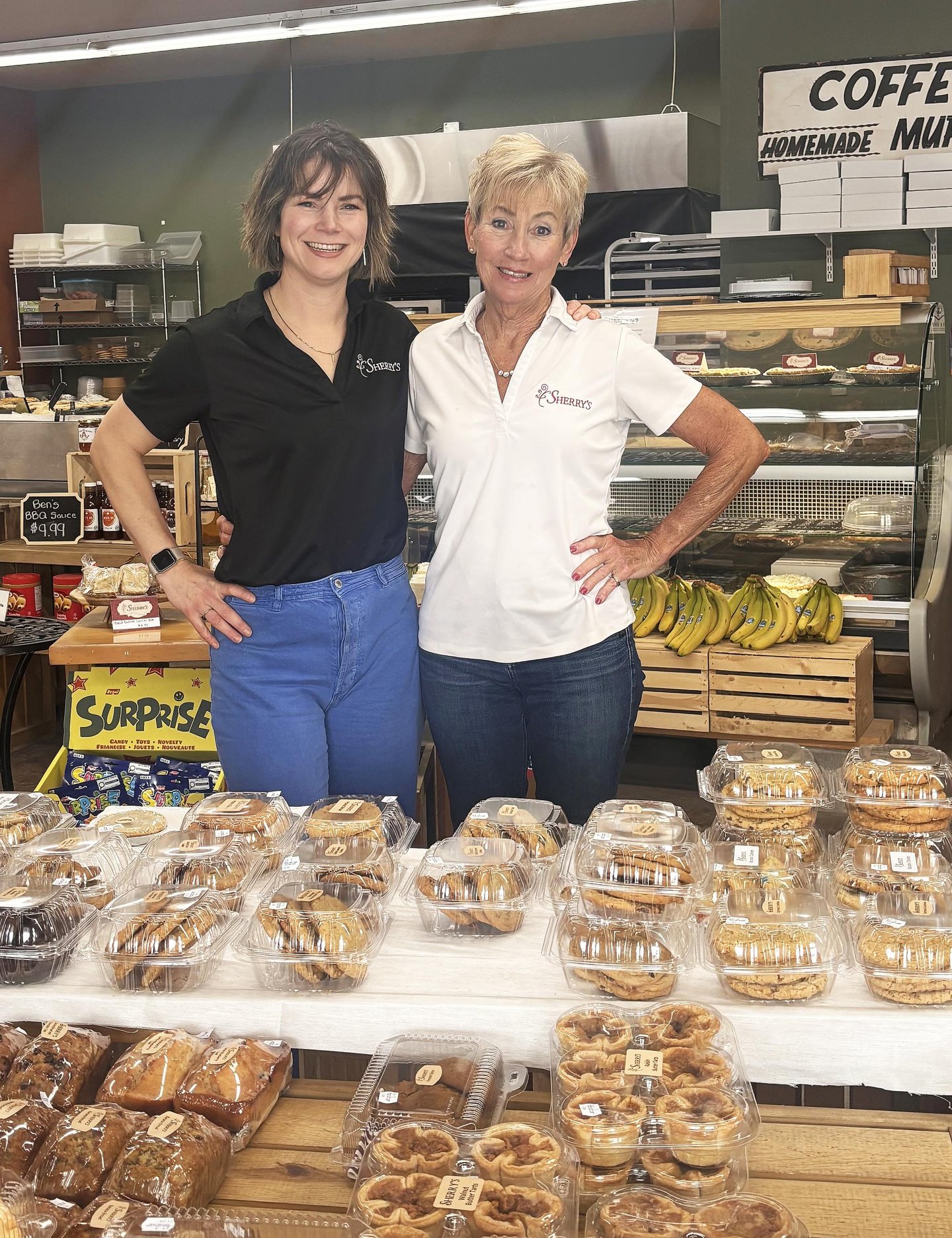 Kayla Helliker (left) and Sherry Mowat (right) owners of Sherry's convenience store standing inf fornt of a selection of baked goods. 