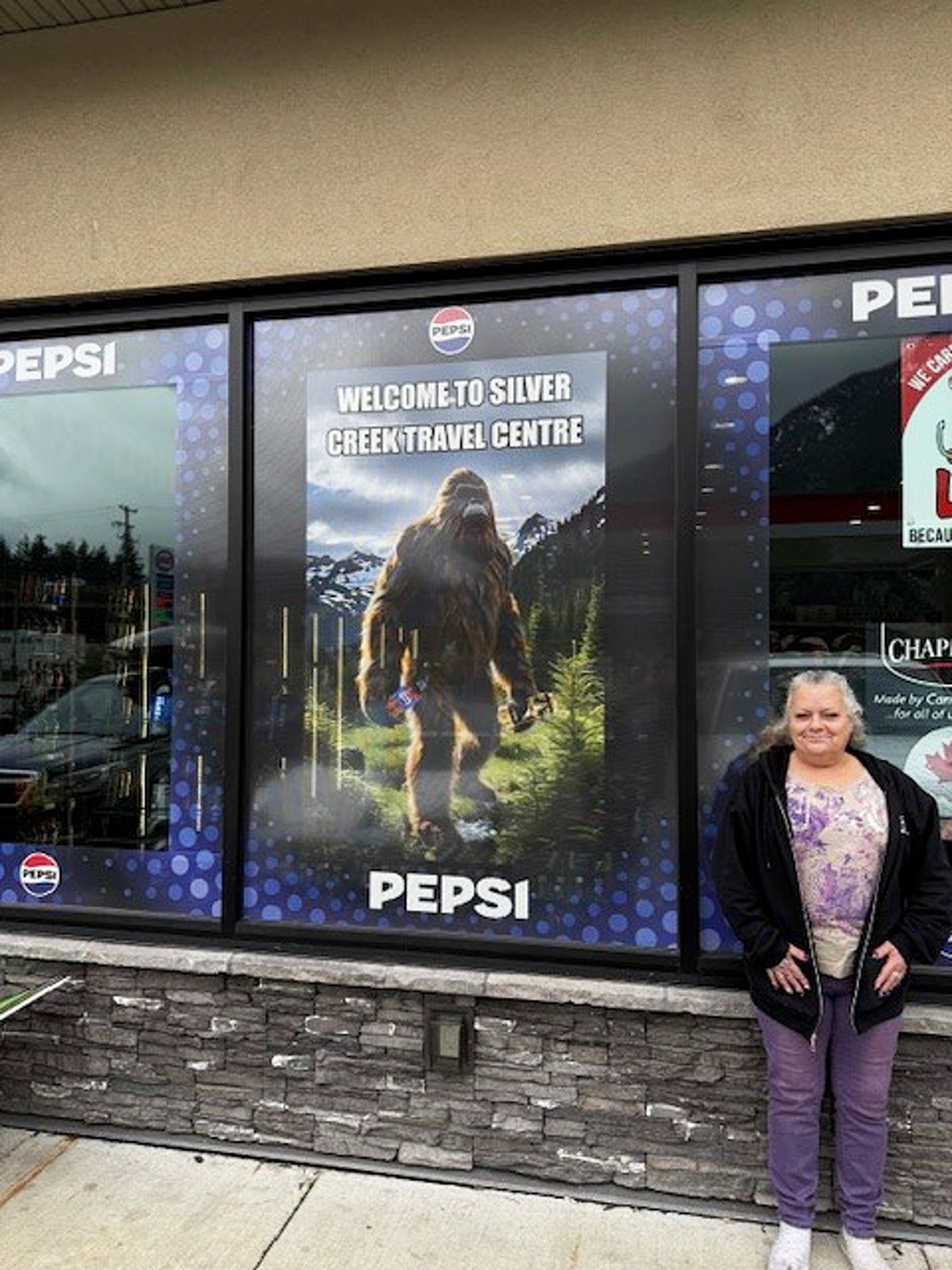 Woman stands in front of Silve Creek Travel Centre window