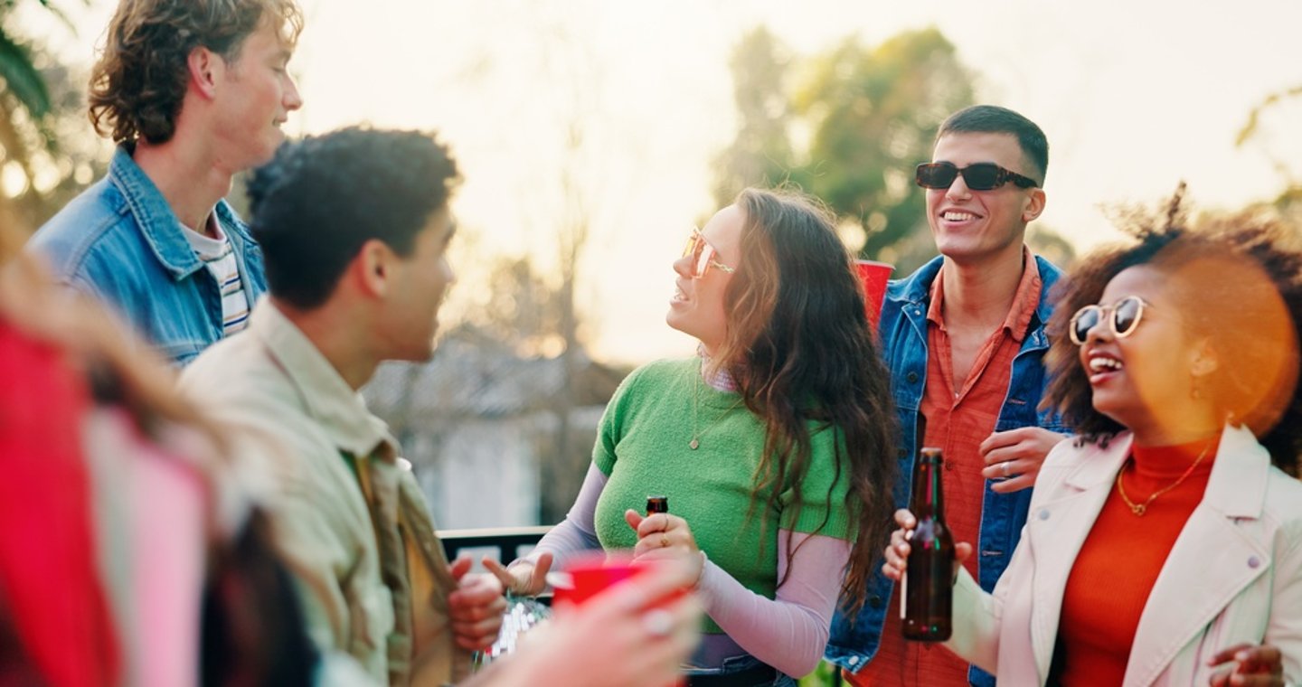 group of young people drinking alcohol outdoors