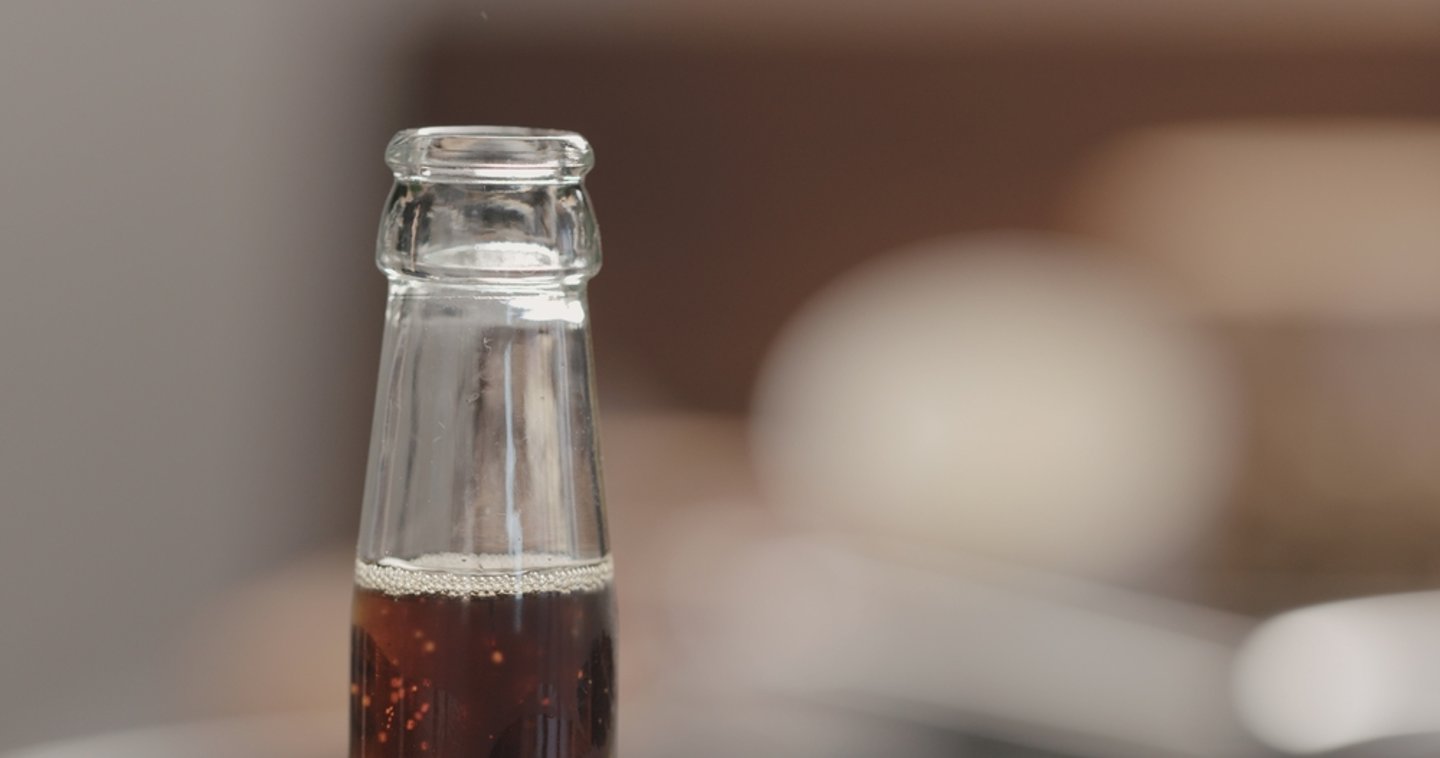 close up of the neck of an uncapped soda bottle  