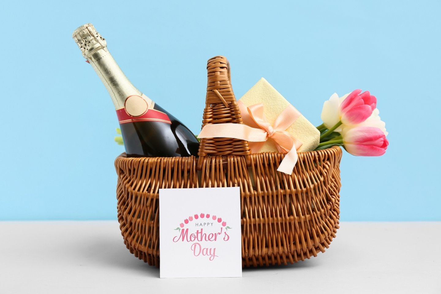 A gift basket of wine, flowers and a mother's day card