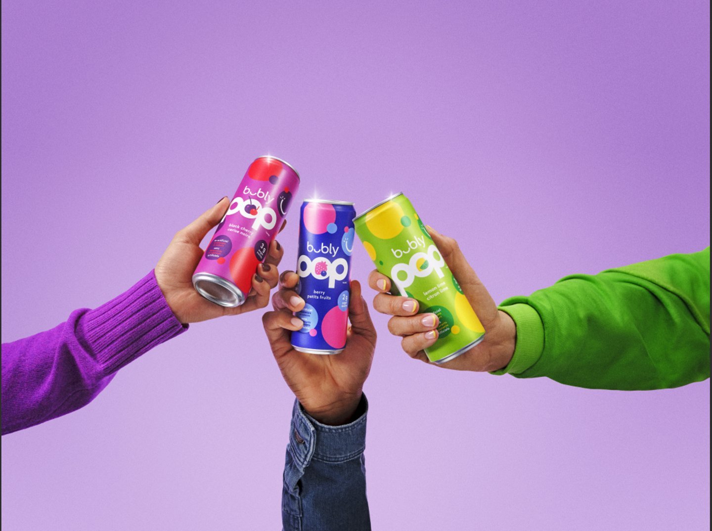 Three arms, each holding a different flavour of Bubly Pop