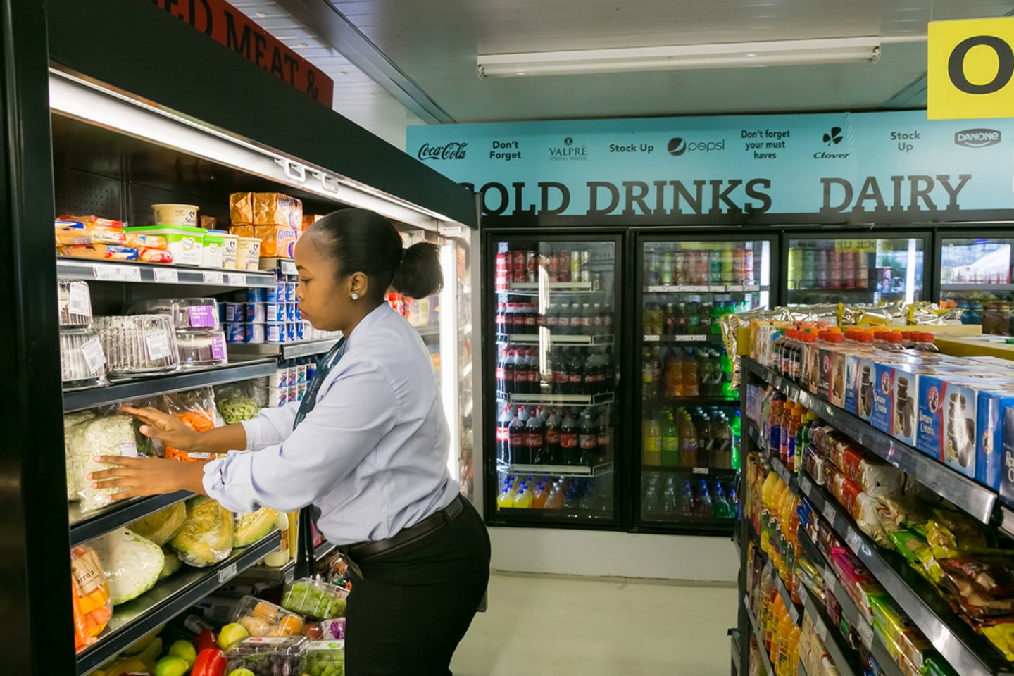woman shopping in front of refrigerated shelves