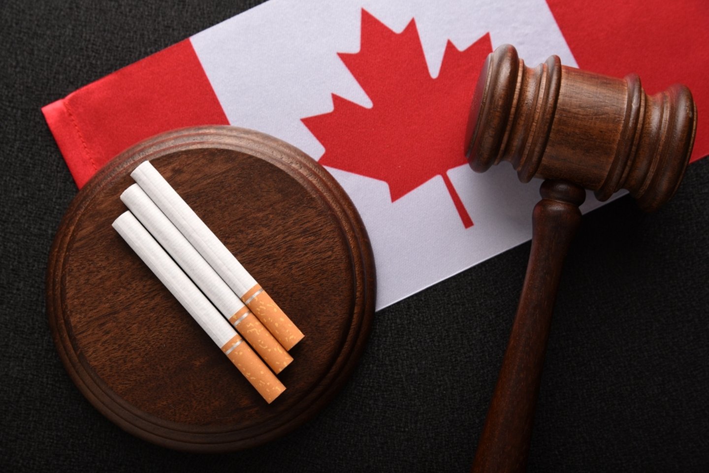 Canadian flag with judge's gavel and cigarettes
