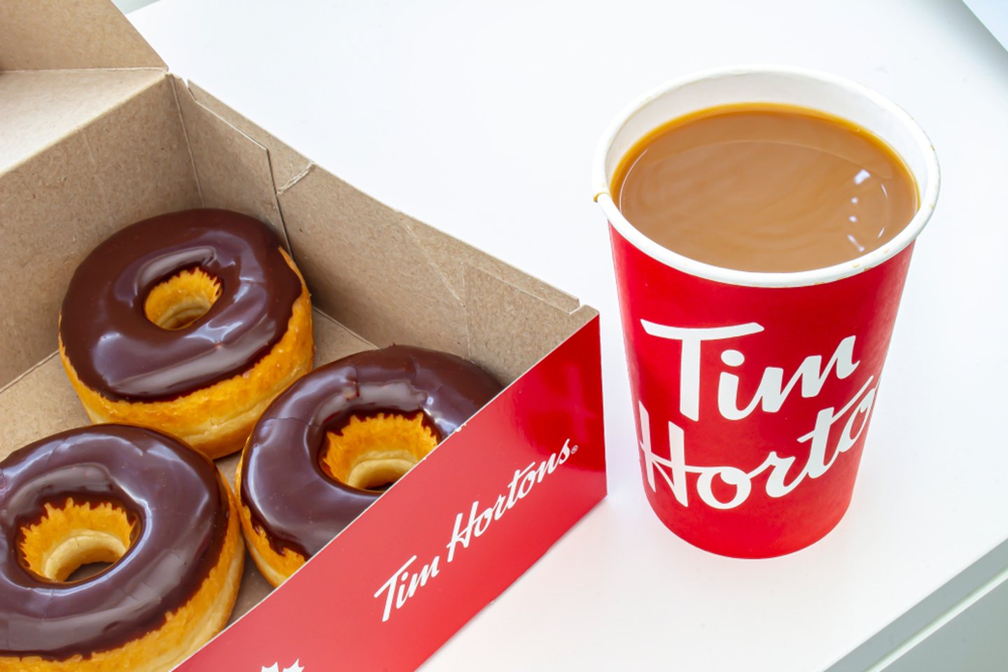 box of chocolate glazed Tim Hortons doughnuts with Tim Hortons coffee