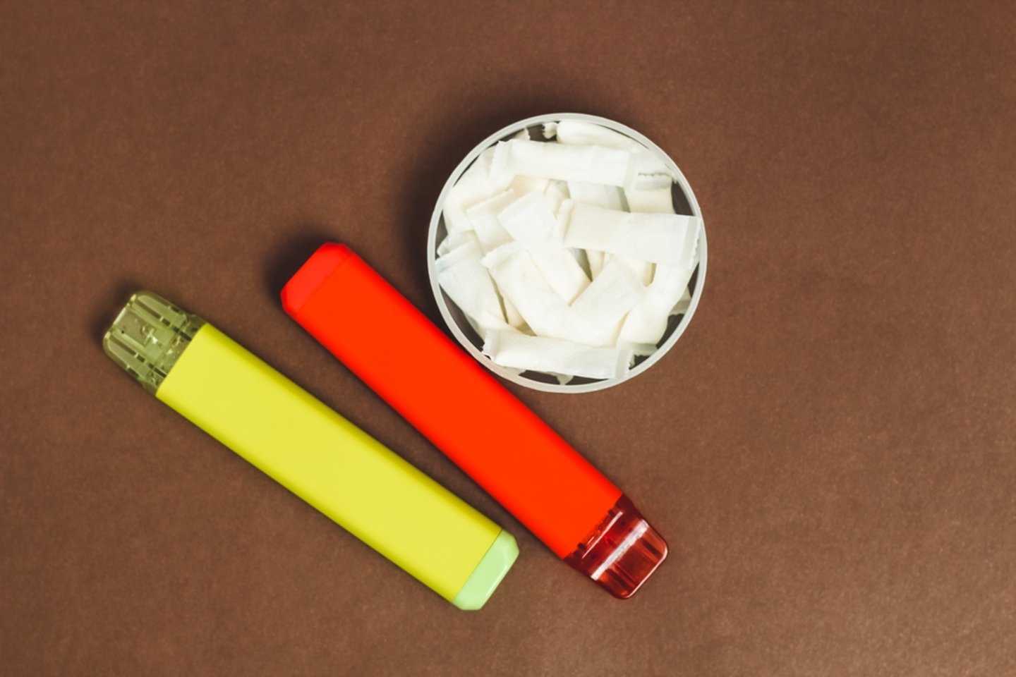 tin of nicotine pouches and two vape cartridges