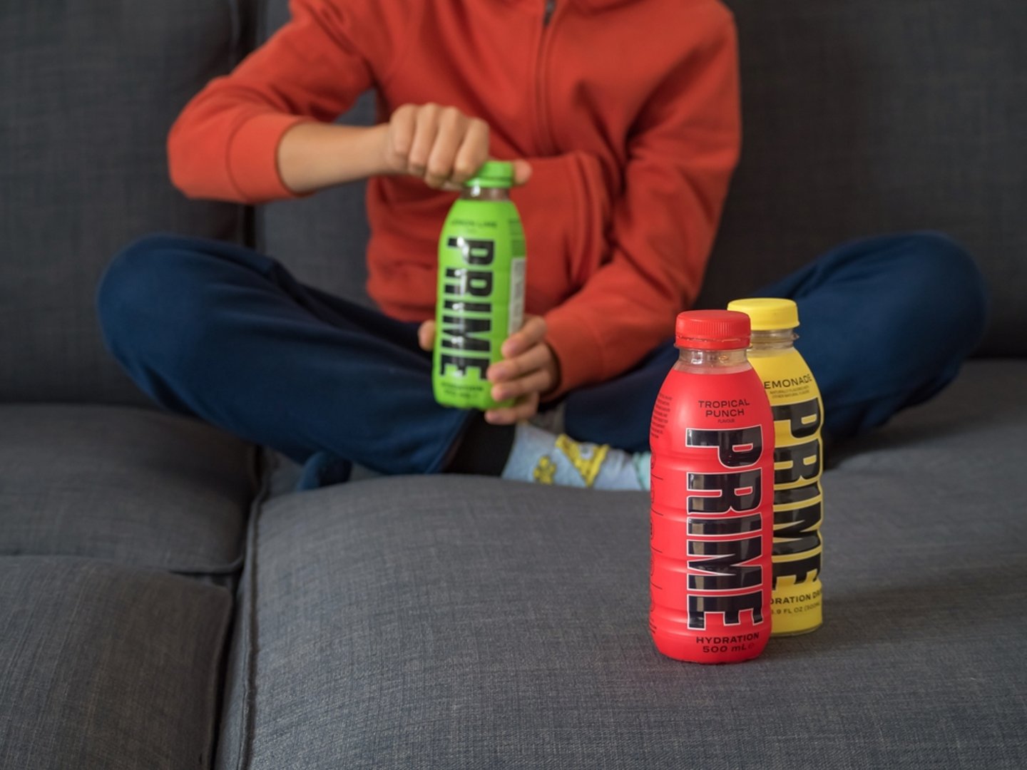 Child opening bottle of Prime energy drink