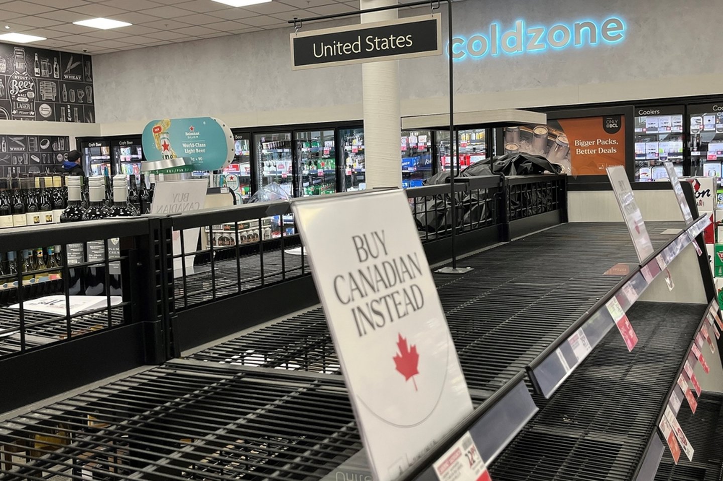 Empty liquor store shelves with "Buy Canadian Instead" sign
