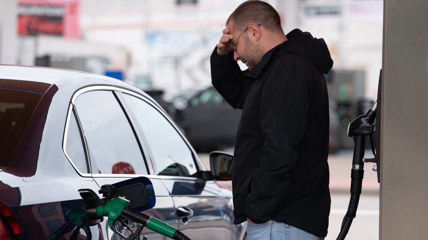 frustrated man pumping gas