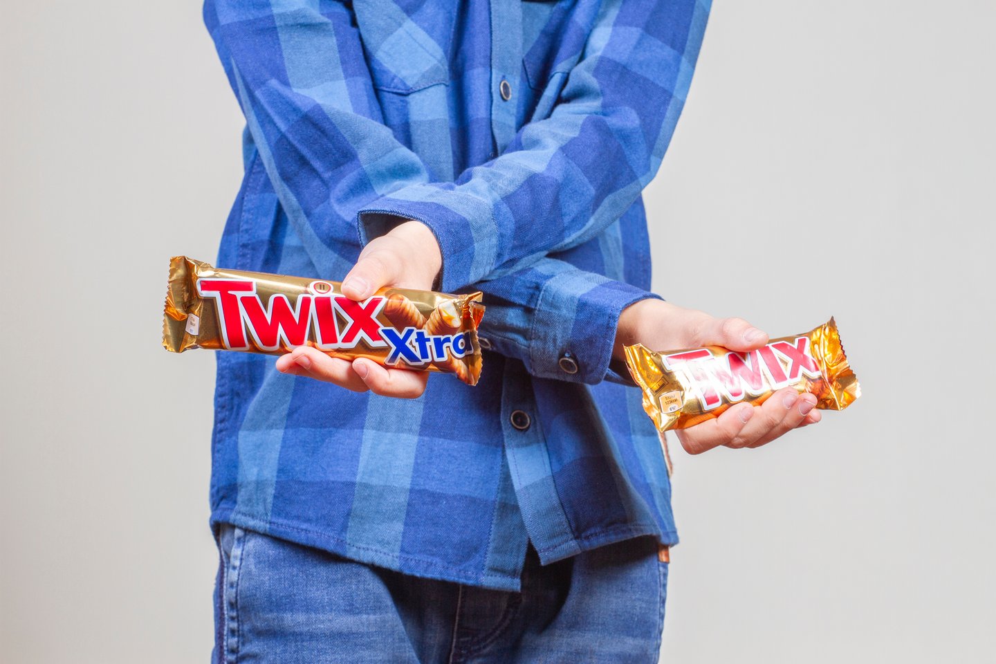 man holding two bars of Twix
