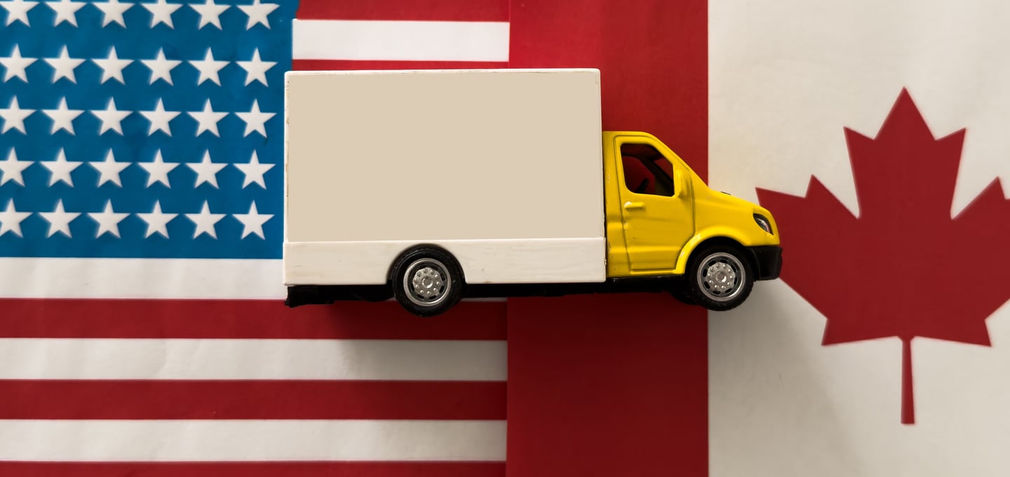 Truck between Canadian and American flags