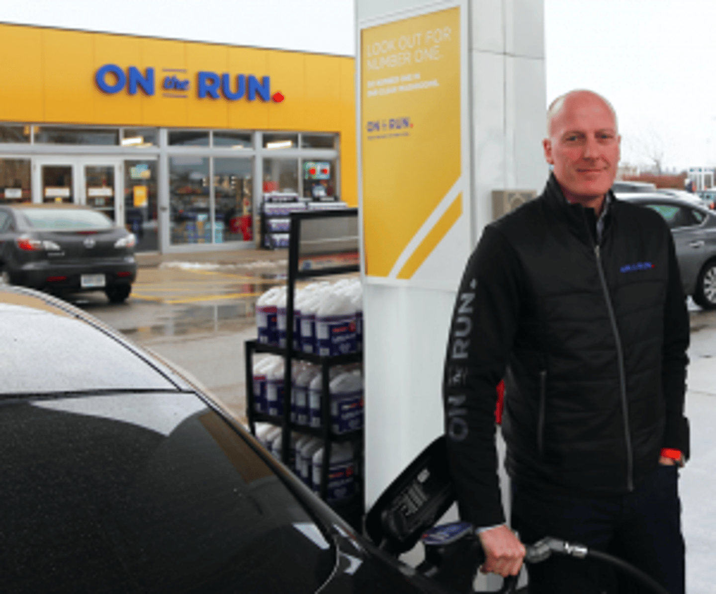 Ian White pumping gas in front of an On the Run