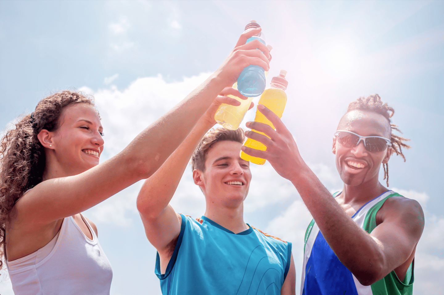 athletes taking a break after training drinking colorful energy drink or sports drink - concept of sports people consuming energetic beverages