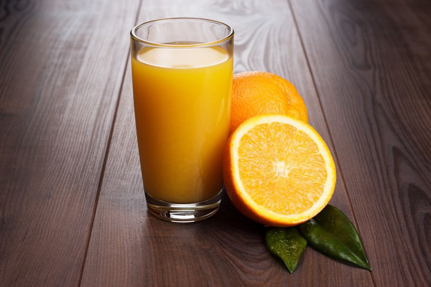 Glass with Juice next to an orange