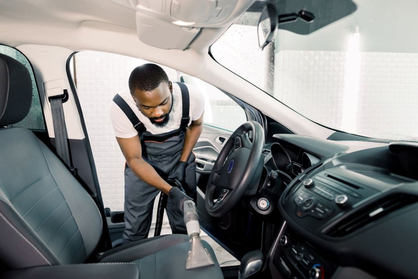 Man Using a Car Wash Vacuum in a car