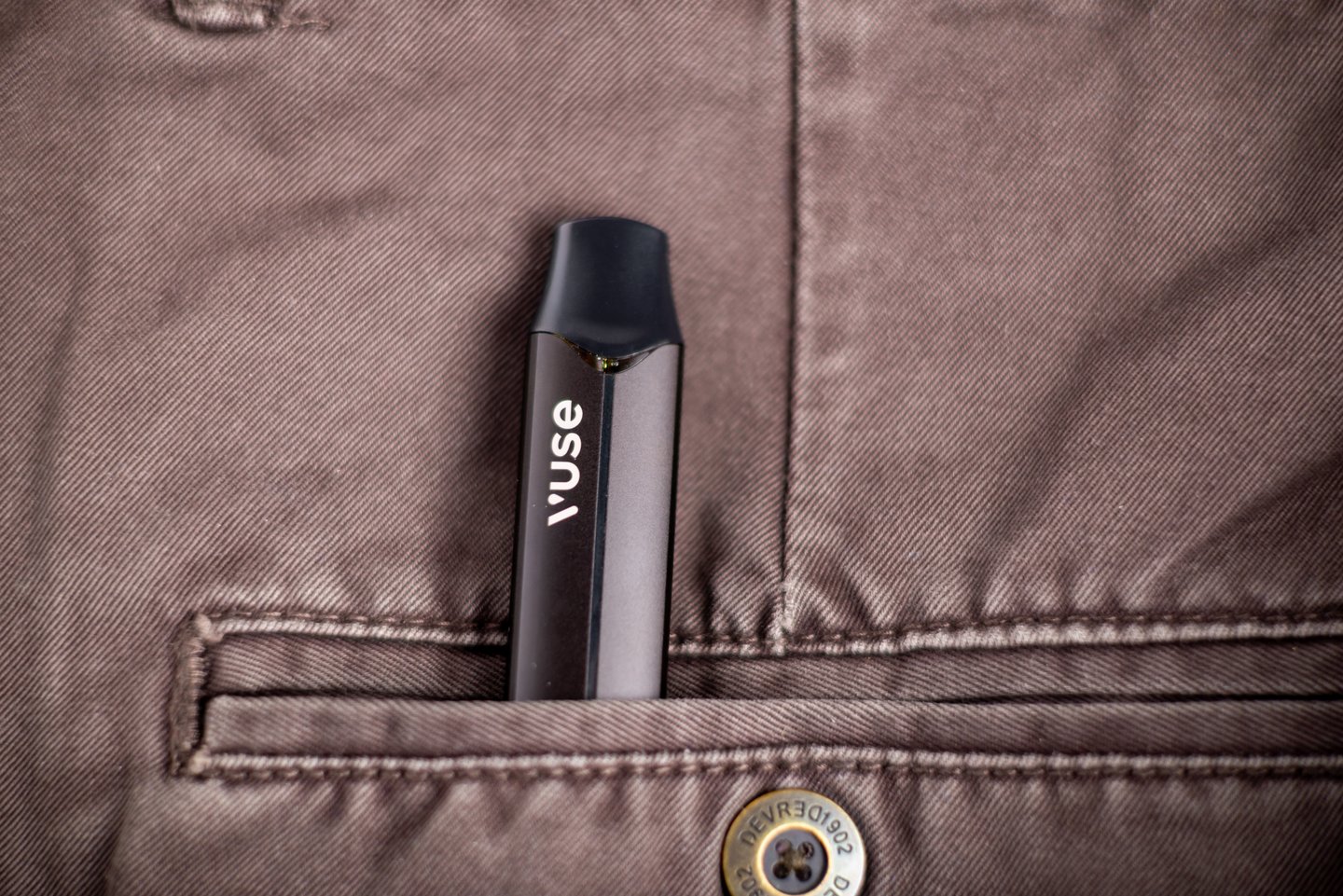 Electronic cigarette Vuse on brown jeans.