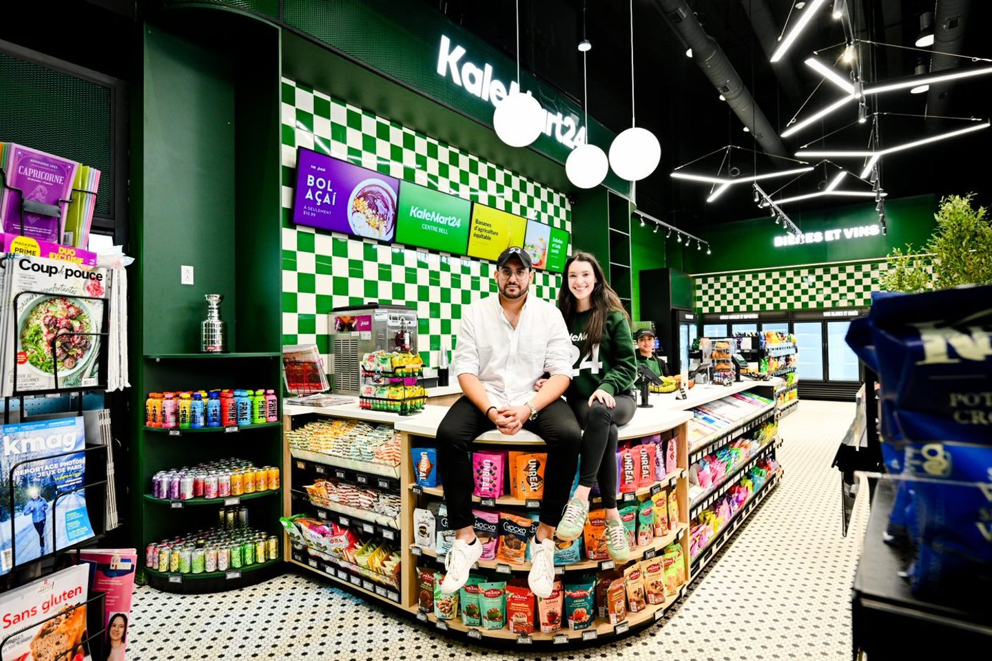 Sam and Liana sitting on the counter at the KaleMart25 store