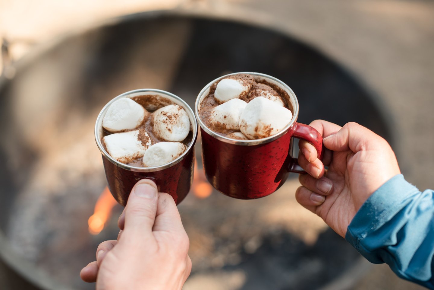 Two cups with hot chocolate in a toasting pattern