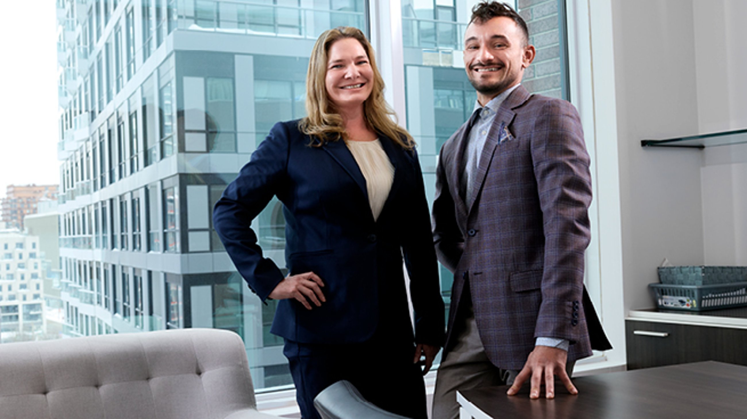 Michelle Lown, senior vice president and Amedeo Catenaro, senior director of franchising, real estate and marketing, stand in front of an office window