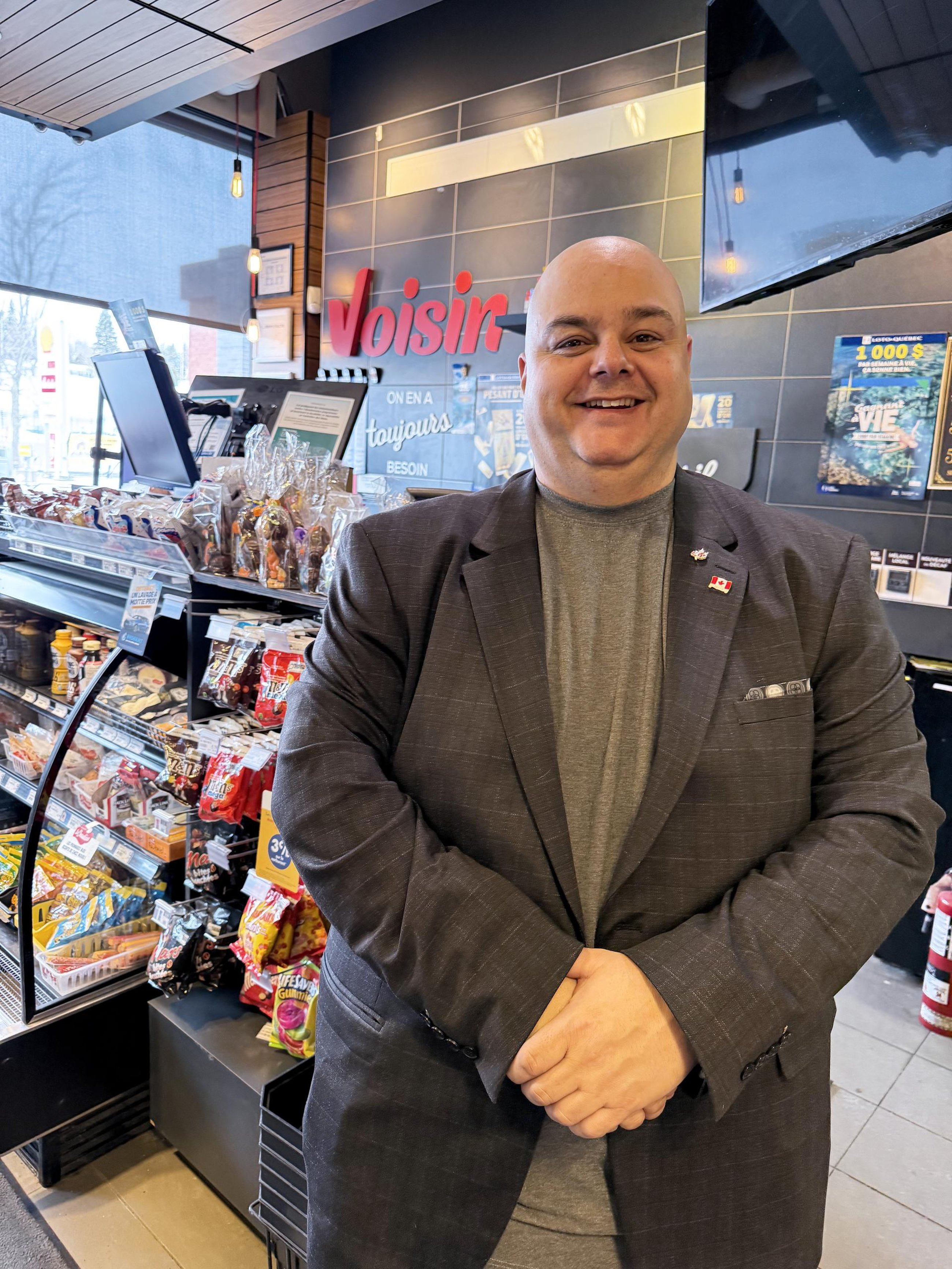 Operator Éric Labranche in front of his counter at Dépanneur Voisin Famille Baril